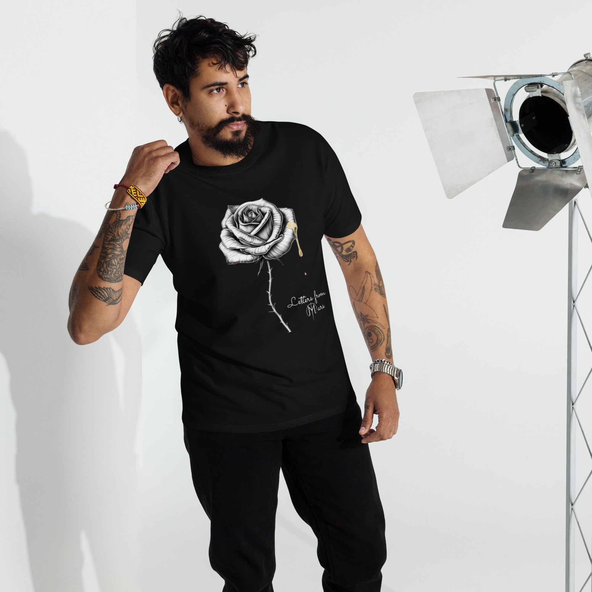 Man wearing a black t-shirt with a Letters from Mars logo and text, standing in front of studio equipment.