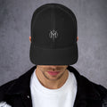Person wearing a black cap with a Letters from Mars M logo on a gray background