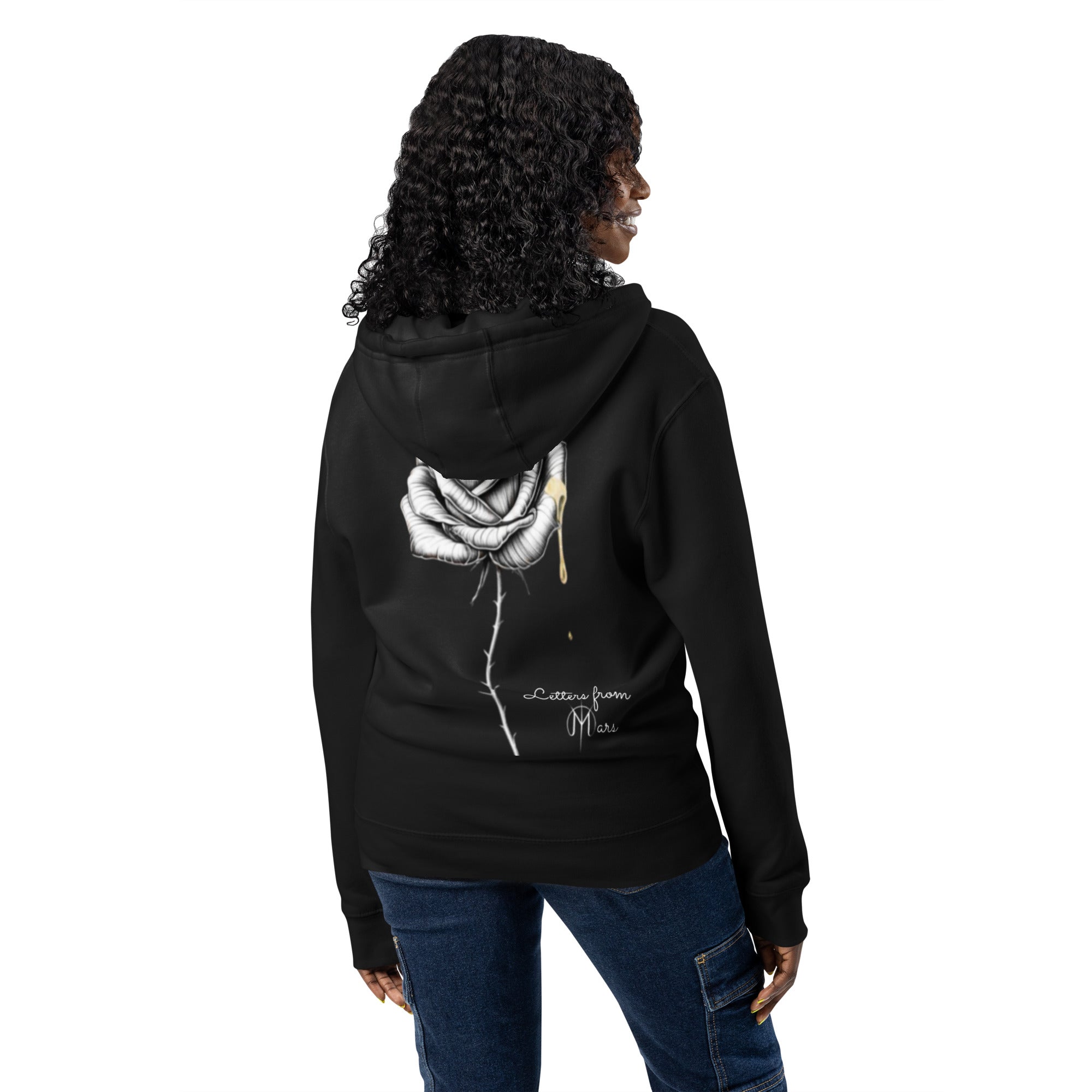 Person wearing a black hoodie with a letters from mars rose design on the back, standing against a white background